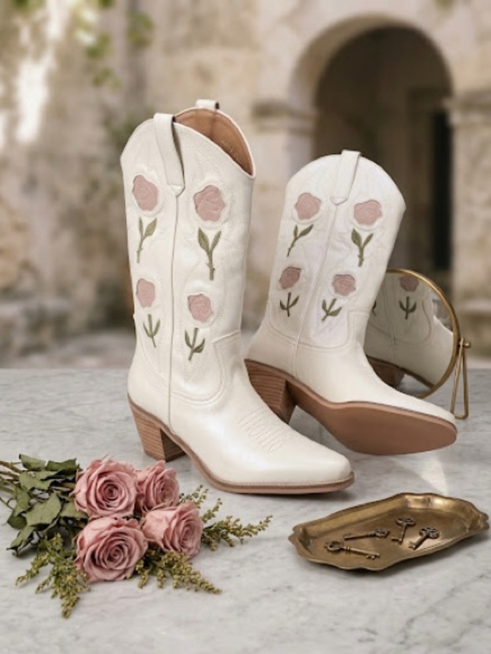 Woman's cowboy boots with pink rose embroidery and green stems